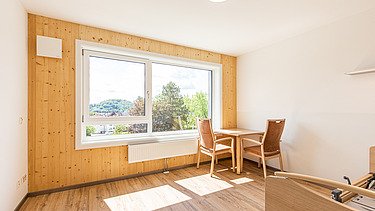 Wohnraum im Elias-Schrenk Haus mit sichtbaren Holzinnenwänden