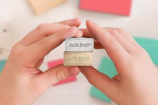 MOLENO - Kombination aus Holz- und Beton-Elementen Das Bild zeigt zwei Kinderhände mit einem Baustein aus Holz und einem aus Beton. Das symbolisiert das MOLENO Bausystem und dessen Hauptkomponenten. Dabei werden Holz und Beton ganz einfach kombiniert, wie bei einem LEGO-System, daher der kindliche Bezug.